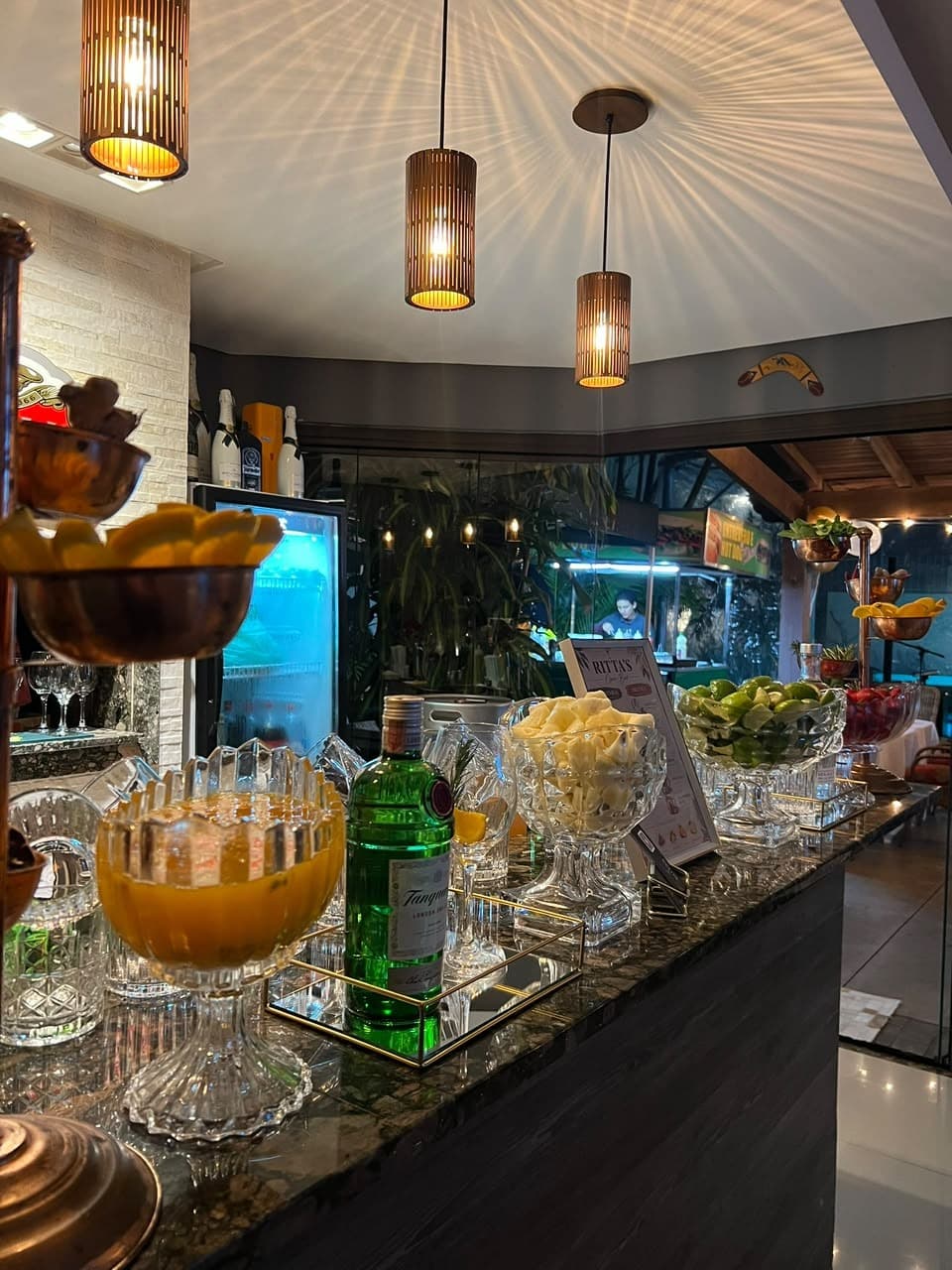 Estrutura do bar montada com ilha de frutas e taças alinhadas para o evento